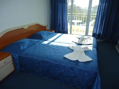 a bedroom with a bed with a dress on it at Pension RUSKOVI GuestHouse in Ravda