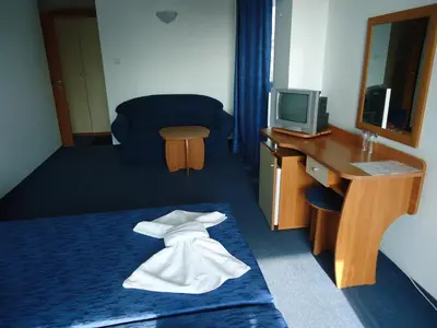 a hotel room with a bed with a towel on it at Pension RUSKOVI GuestHouse in Ravda