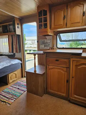 a kitchen in an rv with a bed and a window at Beachfront Caravans in Chernomorets