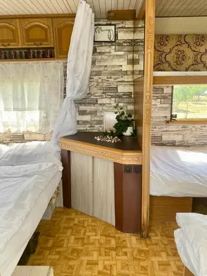 a bedroom with two beds and a desk in a room at Beachfront Caravans in Chernomorets