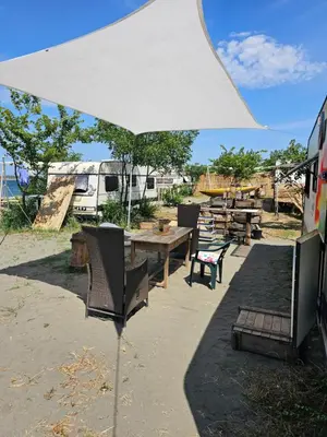 a table and chairs under a white umbrella at Beachfront Caravans in Chernomorets