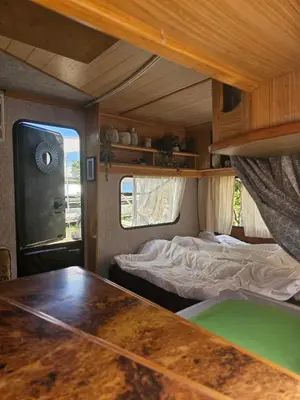 a bedroom with a bed and a table in a rv at Beachfront Caravans in Chernomorets
