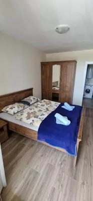 a bedroom with a large bed with a blue blanket at Sarafovo Resort Deluxe in Burgas City