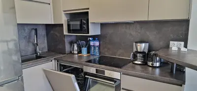 a kitchen with white cabinets and a counter top at Sarafovo Resort Deluxe in Burgas City