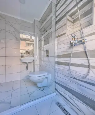 a white bathroom with a toilet and a sink at Villa Alenor | Sea View & Beach Access in Nesebar