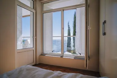 a bedroom with windows and a bed with a view at Villa Alenor | Sea View & Beach Access in Nesebar