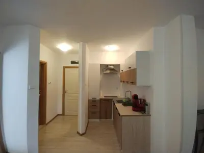 a kitchen with white cabinets and a counter top at Apartament Messambria Resort - Bastet BS in Sunny Beach