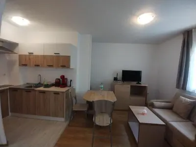 a kitchen and living room with a couch and a table at Apartament Messambria Resort - Bastet BS in Sunny Beach