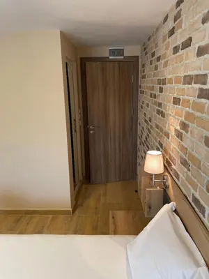 a bedroom with a brick wall and a door at Family Hotel Malibu in Chernomorets