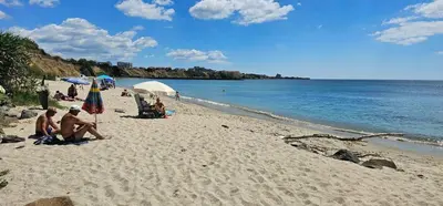 a group of people sitting on a beach at Apartament Sorrento in Marina Cape in Aheloy