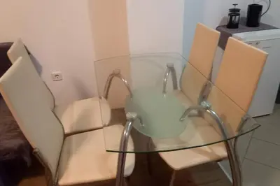 a glass table with two chairs and a glass table at Pomorie Direkt am Pool in Pomorie