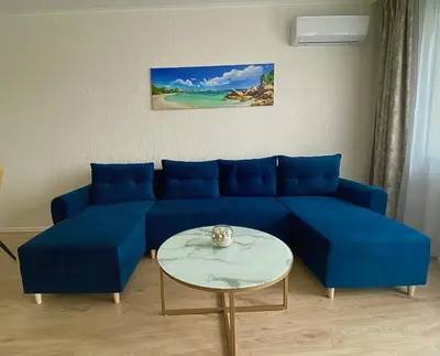 a living room with a blue couch and a table at AVRORA in Varna City