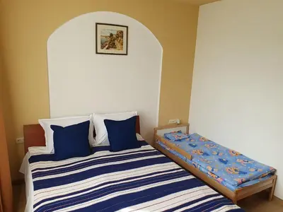 a bedroom with a bed with blue and white pillows at Sea Star Sozopol in Sozopol