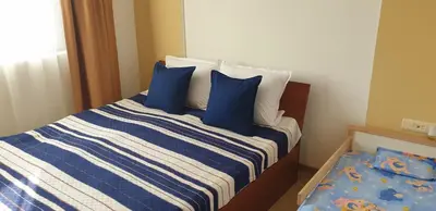 a bed with blue and white sheets and blue pillows at Sea Star Sozopol in Sozopol
