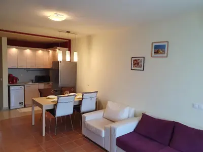 a living room with a couch and a table with chairs at Sea Star Sozopol in Sozopol
