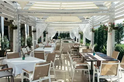 a restaurant with white tables and chairs and a marquee at Sea Star Sozopol in Sozopol