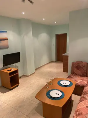 a living room with a table and a tv at Sozopol Apartment 3 in Sozopol