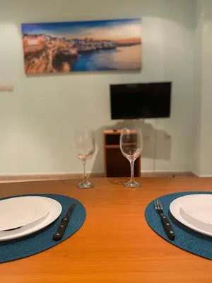 a wooden table with two plates and two wine glasses at Sozopol Apartment 3 in Sozopol