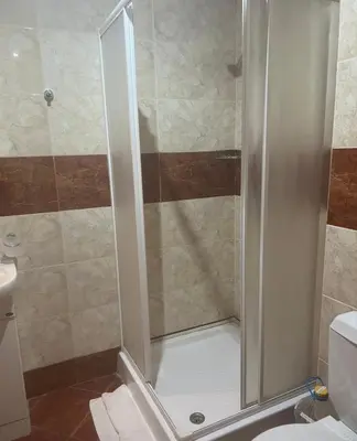 a shower with a glass door in a bathroom at Fort Noks - Marina View in Sveti Vlas