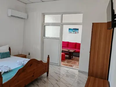 a bedroom with a bed and a red couch at Къща за гости Пиргос in Burgas City