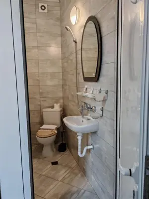 a bathroom with a sink and a toilet and a mirror at Къща за гости Пиргос in Burgas City