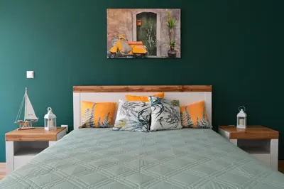 a bedroom with a bed with a green wall at City Center Apartment in Burgas City