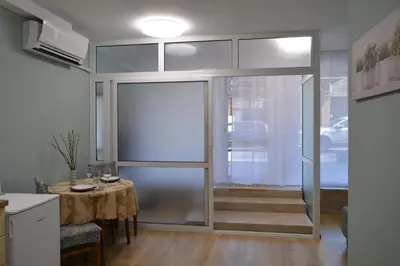 a kitchen with a table and a sliding glass door at City Center Apartment in Burgas City
