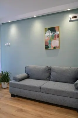 a couch in a living room with a painting on the wall at City Center Apartment in Burgas City