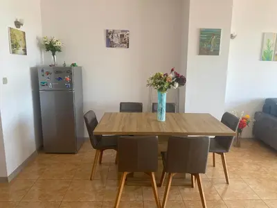 a dining room with a table with chairs and a refrigerator at Gorgeous, 1 Bed Apt, Sea Views. in Duni
