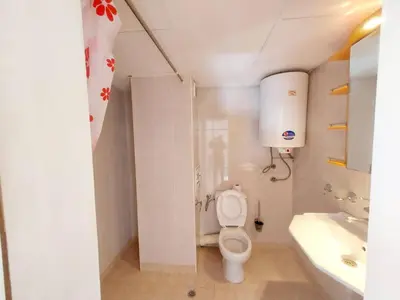 a white bathroom with a toilet and a sink at Comfort Flat in Burgas City