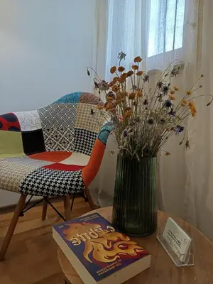 a table with a vase of flowers and a book at Апартамент в Oasis Beach Kamchia -THE FAVOURITE BLUE in Bliznatsi