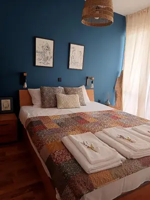 a bedroom with a large bed with blue walls at Апартамент в Oasis Beach Kamchia -THE FAVOURITE BLUE in Bliznatsi