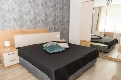 a bedroom with two beds and a mirror at Alagen Apartments Burgas in Burgas City