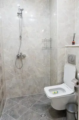 a bathroom with a white toilet and a shower at Alagen Apartments Burgas in Burgas City