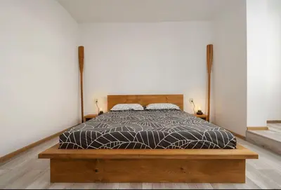 a bedroom with a bed with a wooden bed frame at Boutique Blue Apartment in Sveti Vlas