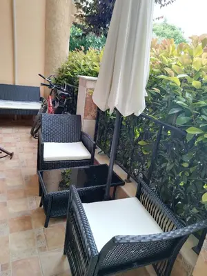 a patio with three chairs and an umbrella at MARINA Apartments in Ravda