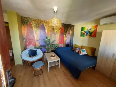 a room with a bed and a table and surfboards at Surf house in Burgas City