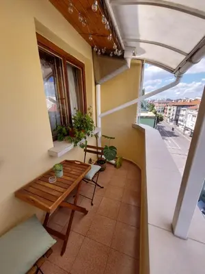 a balcony with a wooden table and a window at Surf house in Burgas City