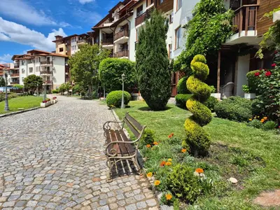 a park bench in a park with flowers and bushes at Garden of Eden - Apartament Niya in Sveti Vlas