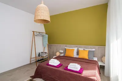 a bedroom with a bed with a green wall at Greek quarter flat two BR next to Sea Garden in Varna City