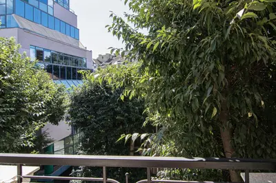 a bench in front of some trees and a building at Greek quarter flat two BR next to Sea Garden in Varna City