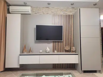 a living room with a tv on a wall at Green Line Apartament Sozopol in Sozopol
