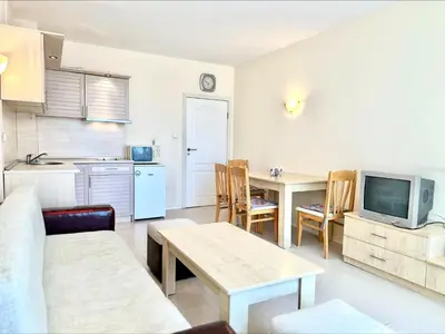 a living room with a couch and a table and a kitchen at Blue Marine - Menada Apartments in Sunny Beach