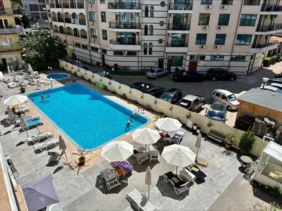 an overhead view of a swimming pool with chairs and umbrellas at Blue Marine - Menada Apartments in Sunny Beach