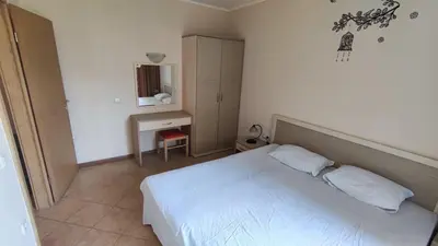 a bedroom with a white bed and a desk at Royal Sun Complex in Sunny Beach