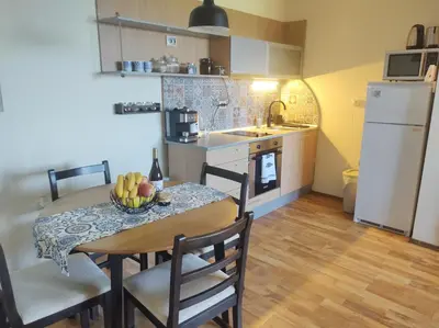 a kitchen with a table with a bowl of fruit on it at Апартамент в Oasis beach Kamchia - Стъпки в пясъка in Kamchia