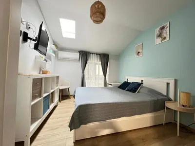 a bedroom with a bed and a tv and a window at Мореплавателите / The seafarers in Sozopol