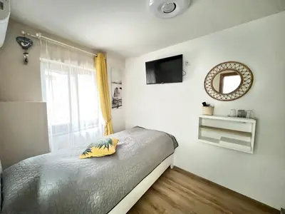 a bedroom with a bed with a yellow pillow on it at Мореплавателите / The seafarers in Sozopol