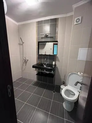 a bathroom with a toilet and a tv on the wall at Sea View 2BR Apartment Sozopol in Sozopol