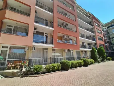 an apartment building with balconies and a brick sidewalk at Сънсет Бийч 3 in Sunny Beach